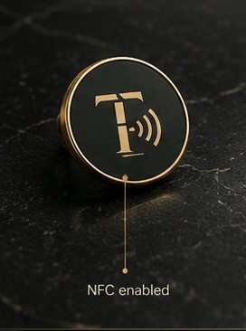 ThankTap lapel pin badge in black and gold on marble
